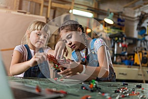 Young girls building toy construction machine photo