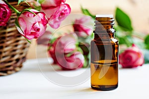 Small glass bottle with essential rose oil. Aromatherapy, spa and herbal medicine ingredients.