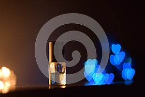 Small glass bottle with perfume and bokeh background photo