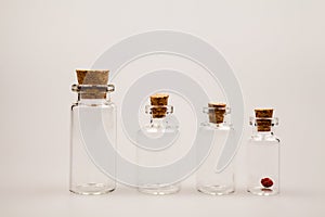 Small glass bottles with cork and reflexions