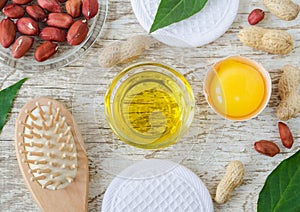 Small glass bowl with cosmetic cleansing, massage peanut oil, raw egg and wooden hairbrush. Natural haircare, homemade spa