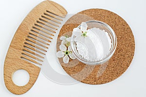 Small glass bowl with epsom bath salts foot soak and wooden hair brush. Natural spa, beauty treatment, zero waste concept.