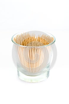 A small glass filled with toothpicks, isolated on white background