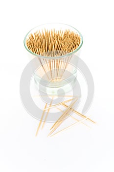 A small glass filled with toothpicks, isolated on white background