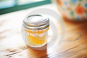 a small glass jar filled with homemade lip balm