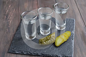 Small glass with Russian vodka and salt cucumber