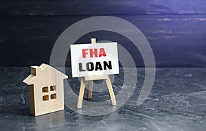 Small gouse and FHA loan easel sign. High risk of default. Mortgage insured by Federal Housing Administration Loan. An affordable