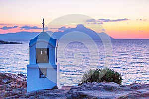 Small greek chapel and mount Athos at sunrise or sunset with sea panorama