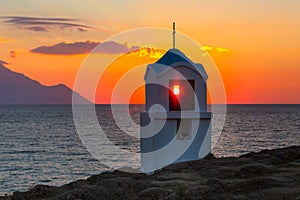 Small greek chapel and mount Athos at sunrise or sunset with sea panorama