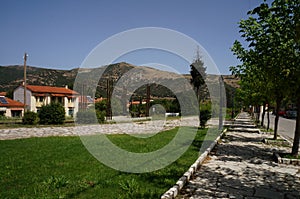 A small Greek village hidden in the foothills of the mountains along an empty road