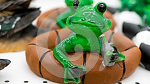 Ceramic green frog in a frivolous pose photo