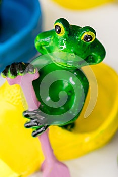 Ceramic green frog in a frivolous pose photo