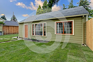 Small green guest house in the fenced backyard. photo