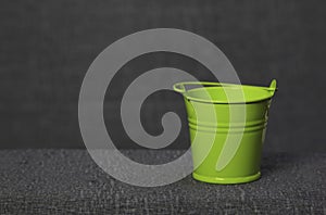 Small green pail on gray background