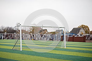 a small green soccer field and a white gate