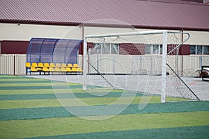 a small green soccer field and a white gate