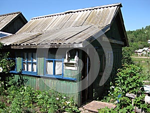 small green wooden board country house in the village in the Russian remote places, Oktyabrsky, Bashkiria, Russia