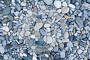 Small grey pebbles cover sea beach for visitors to relax