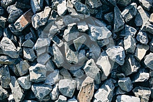 Small grey stones of road metal lying on the ground