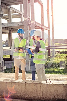 Small group of architects and civil engineers meeting on a construction site