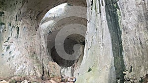 A small group of tourists exploring Prohodna Cave in Bulgaria.