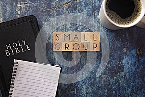 Small Group Written in Block Letters on a Wooden Table with a Black Bible