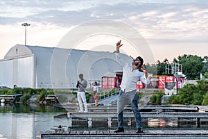 small group of young multi-ethnic friends having fun on the docks of a river port