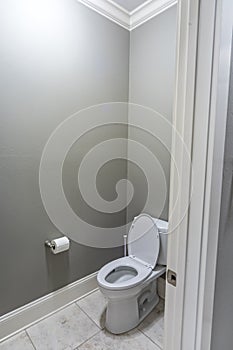 A small half bathroom with gray walls and a toilet with tile floors in a new construction house
