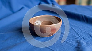 Bowl is placed on a blue fabric which provides a contrasting