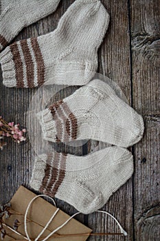 Small handmade baby socks on dark wooden background