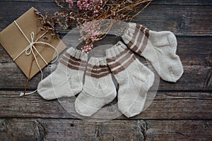 Small handmade baby socks on dark wooden background