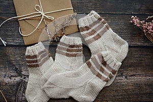 Small handmade baby socks on dark wooden background