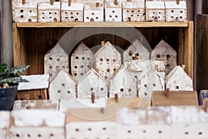 Small handmade wooden houses in a row on store shelf. Craft, home decor concept. Scandinavian, country style