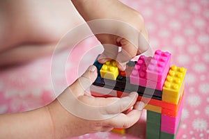 Small hands of the child collects the bright plastic colored Designer. Educational toys and Early learning