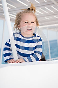 Small happy baby boy on yacht in marine shirt, fashion
