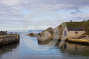 The small harbor at Ballintoy on the North Antrim Coast of Northern Ireland with its stone built boathouse on a day in spring