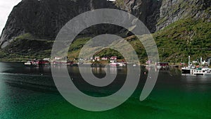 Small harbor with settlement at mountain foot aerial view