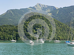 Small harbor in Wolfgangsee mountain lake. Anchored yachts, sunny weather.