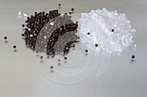 A Small Heap of Seasalt and Peppercorns on Reflective Surface photo