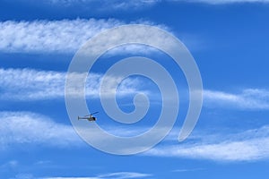 Small helicopter on big blue sky