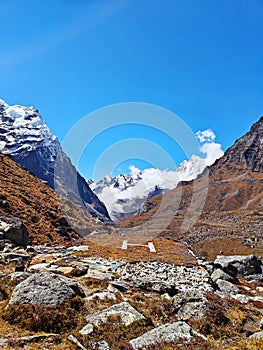 Small helipad in Nepal's Himalayas surrounded by high peaks and blue skies
