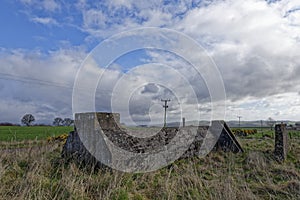 A small hidden reinforced concrete Wartime Bunker with the Entrance protected by Concrete Blast Walls photo