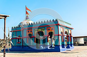 Small hindu temple with carvings in vivid blue and reds shot in gujarat india