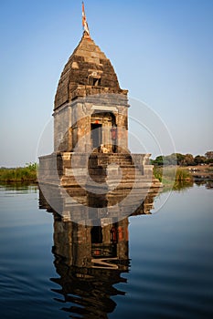 Small Hindu temple in the middle of the holy Narmada River, Maheshwar, Madhya Pradesh state, India