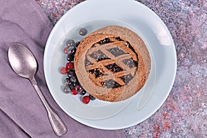 Small homemade tartlet called `Linzertorte`, a traditional Austrian shortcake pastry topped with fruit preserves