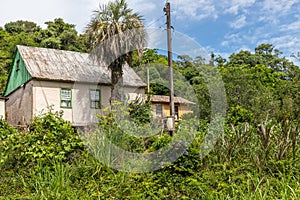 Small house in enxaimel style, dirty road with flowers and plants around photo