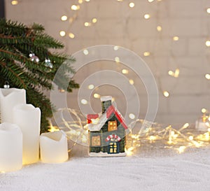 Small house with glowing windows in a blurred background for a collage on the theme of Christmas and New Year with a glowing