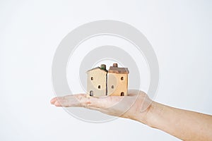 Small house in human hands on a white background.