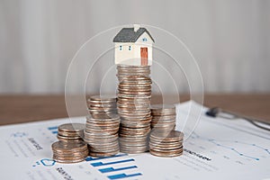 The small house model is placed on top of the coin