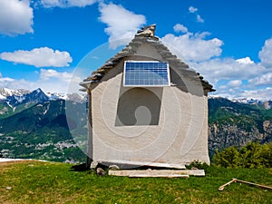 small house on a mountain ridge with solar panel